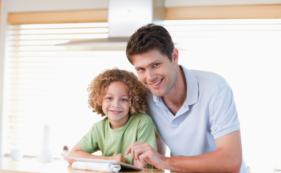 Smiling boy and his father using a tablet computer